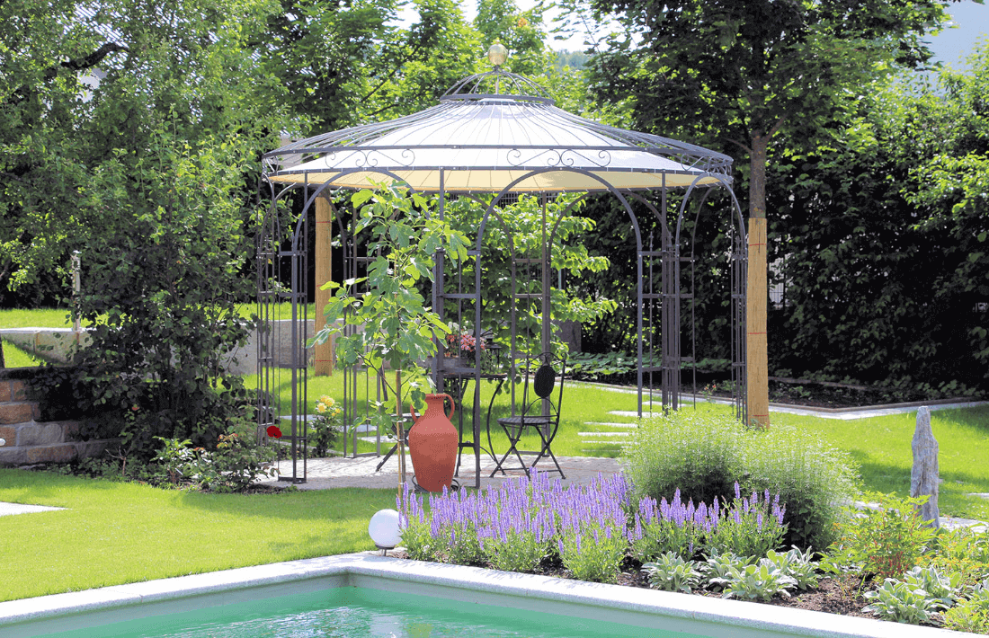 Pavillon Florenz in pulverbeschichteter Ausführung mit Messingkugel und Sonnensegel hinter einem Gartenteich
