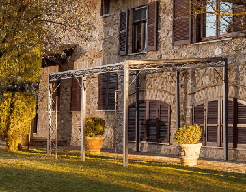 Pergola Sicilia pulverbeschichtet anthrazit mit Sonnensegel vor einem mediterranen Haus