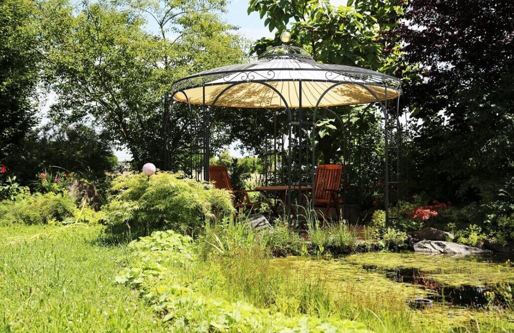 ELEO Pavillon Florenz in Garten integriert neben einem Gartenteich